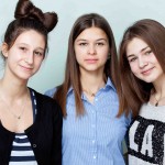 School. Fellowship. Three young ladies hugging each other , smiling